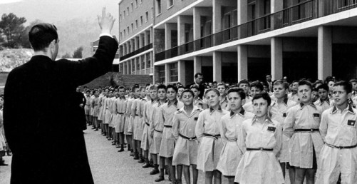 Un sacerdote junto a niños internados en Llars Mundet, en Barcelona. 